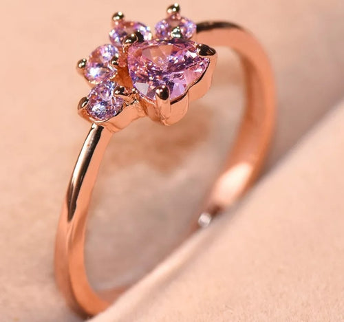 Anillo patita oro rosa vista lateral sobre tela