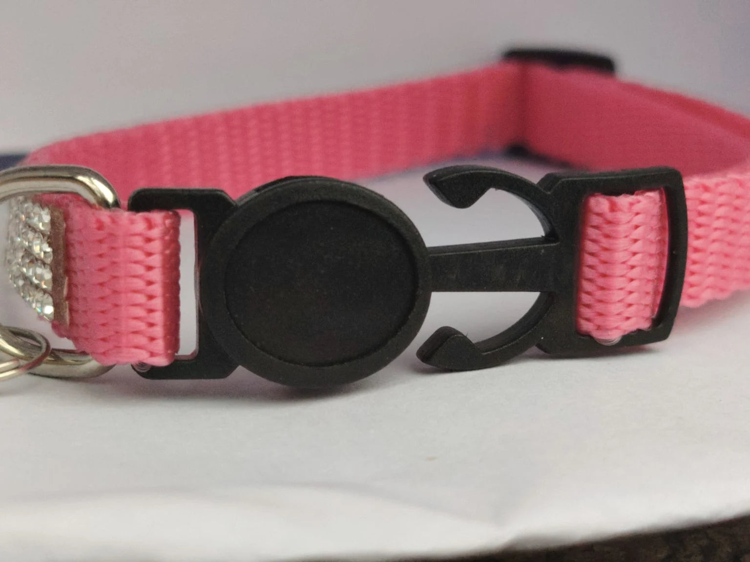 Foto real del cierre negro del collar rosado